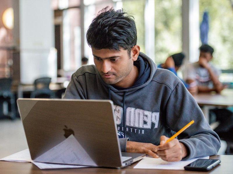 Student sitting at desk with laptop